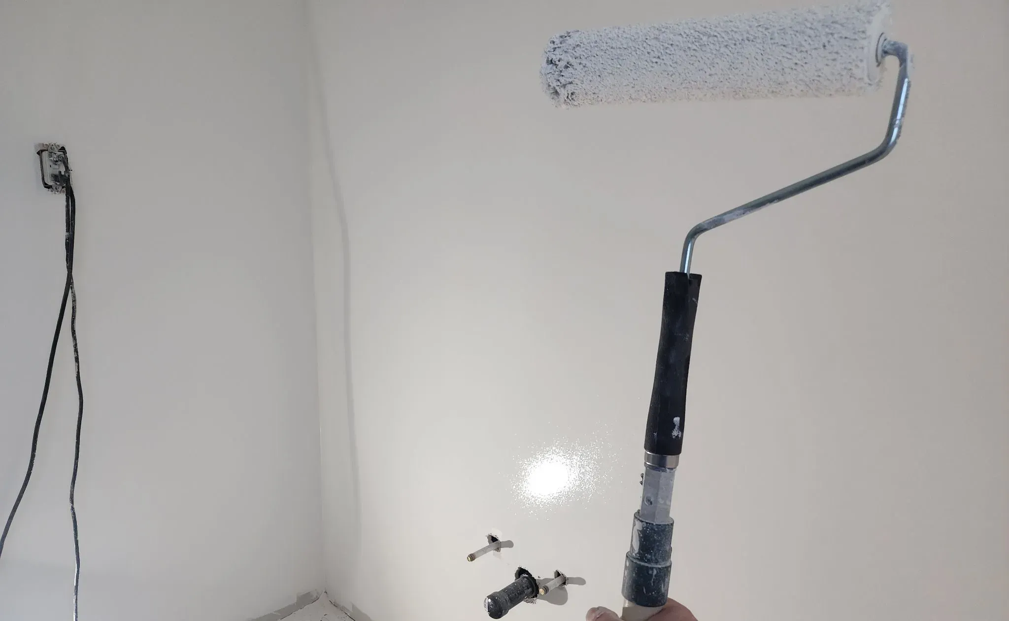 Rolling paint onto a freshly finished wall
